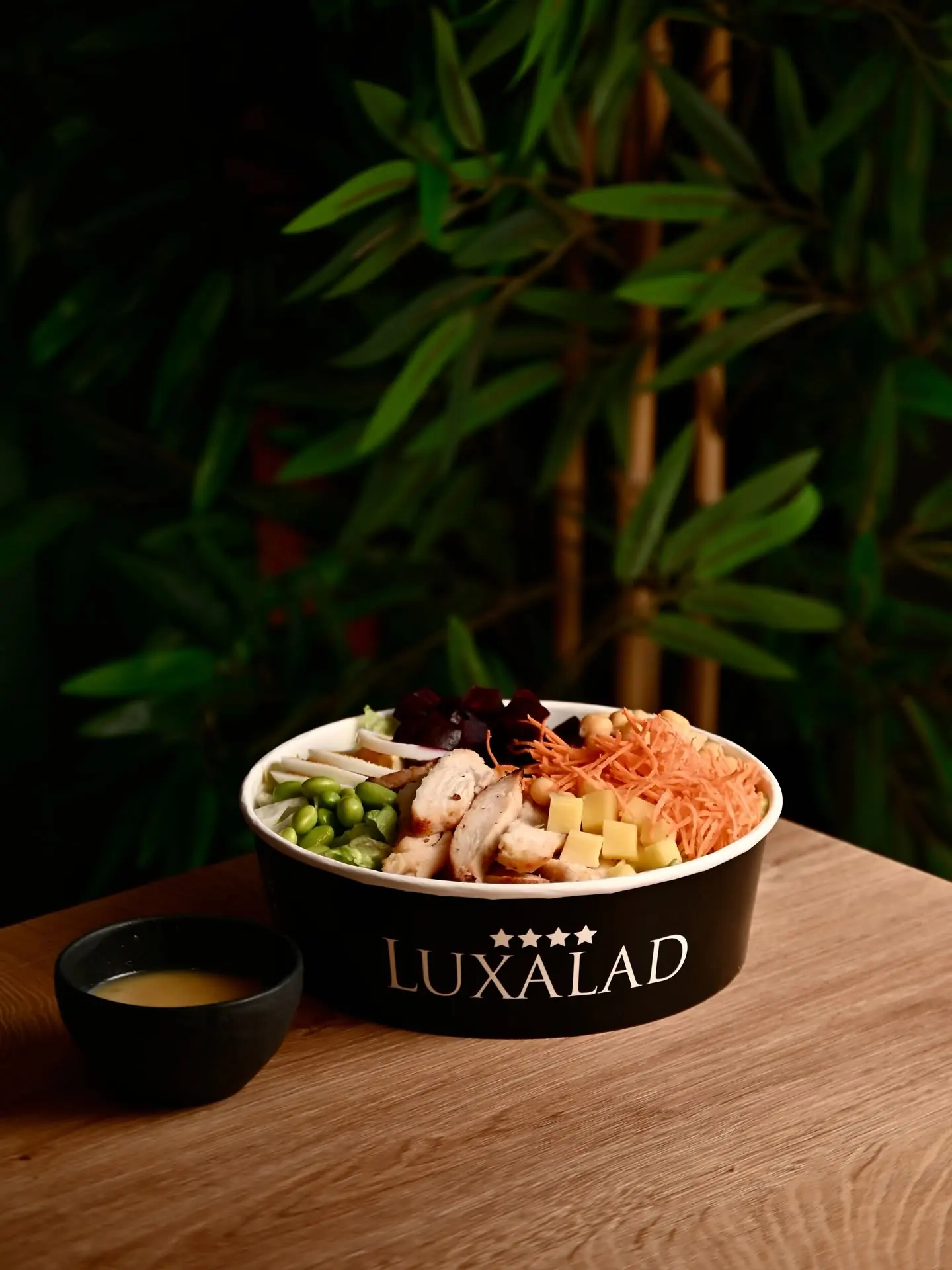 A Luxalad bowl on a dark table against bamboo