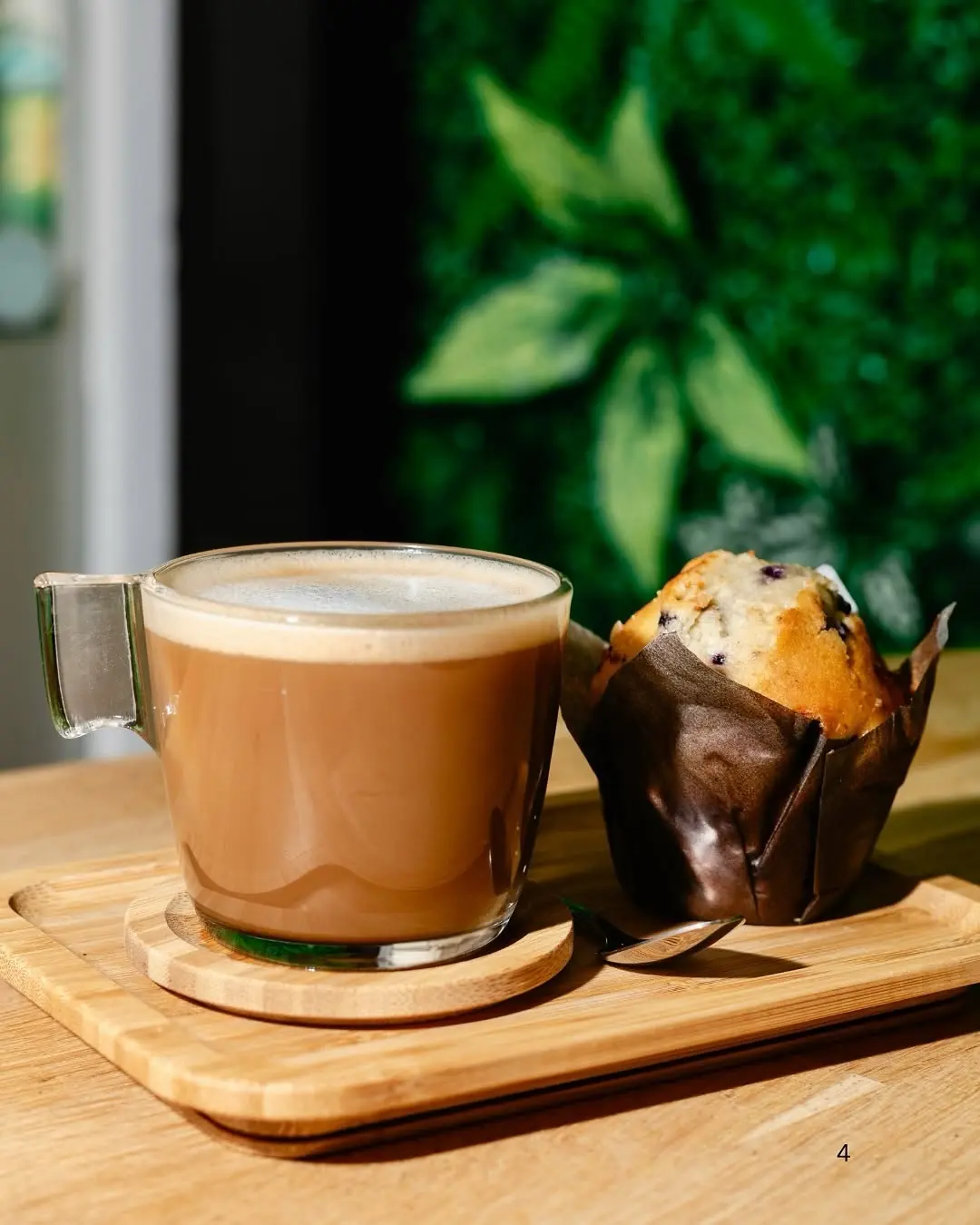 A coffee and a muffin on a dark board