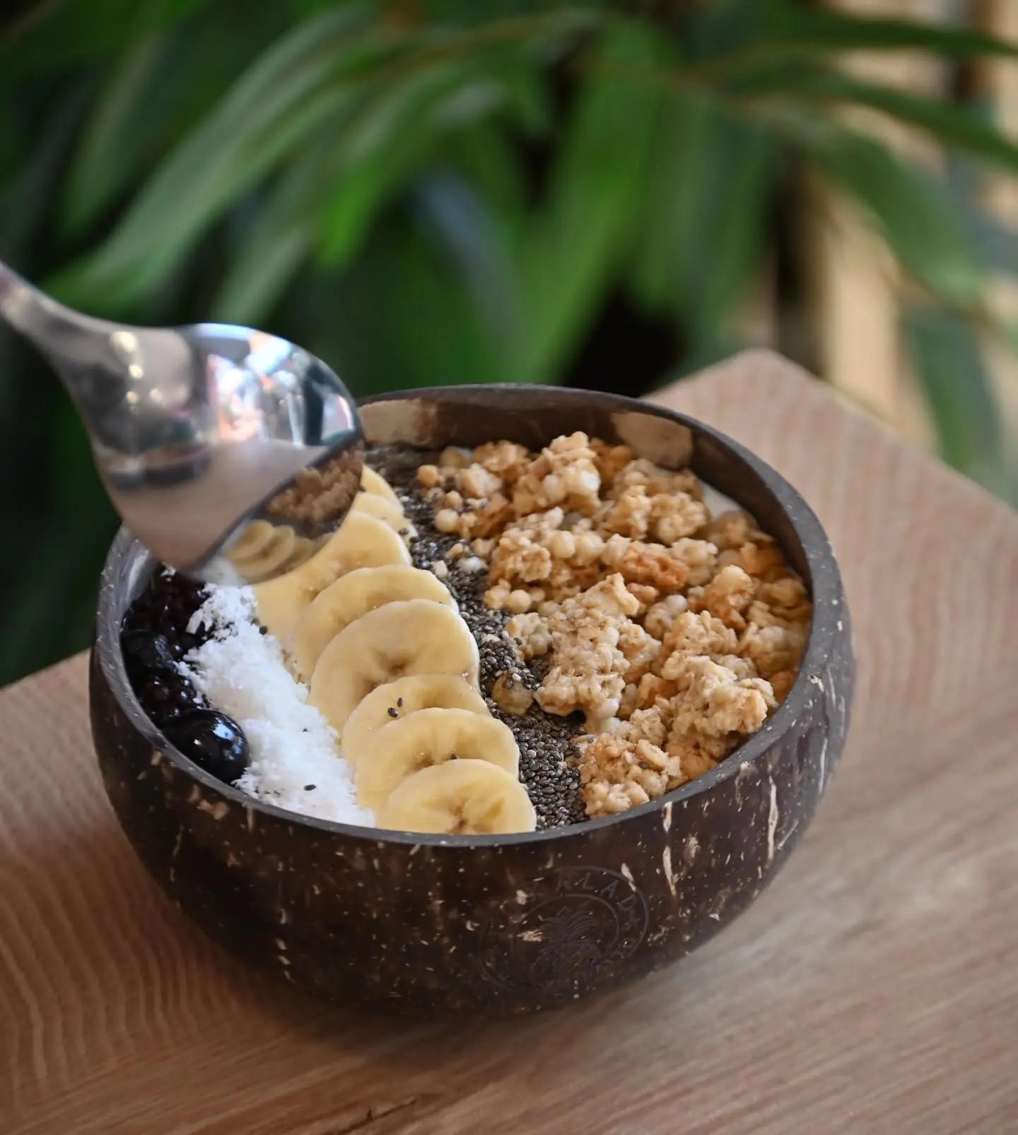 A smoothie bowl topped with granola and banana