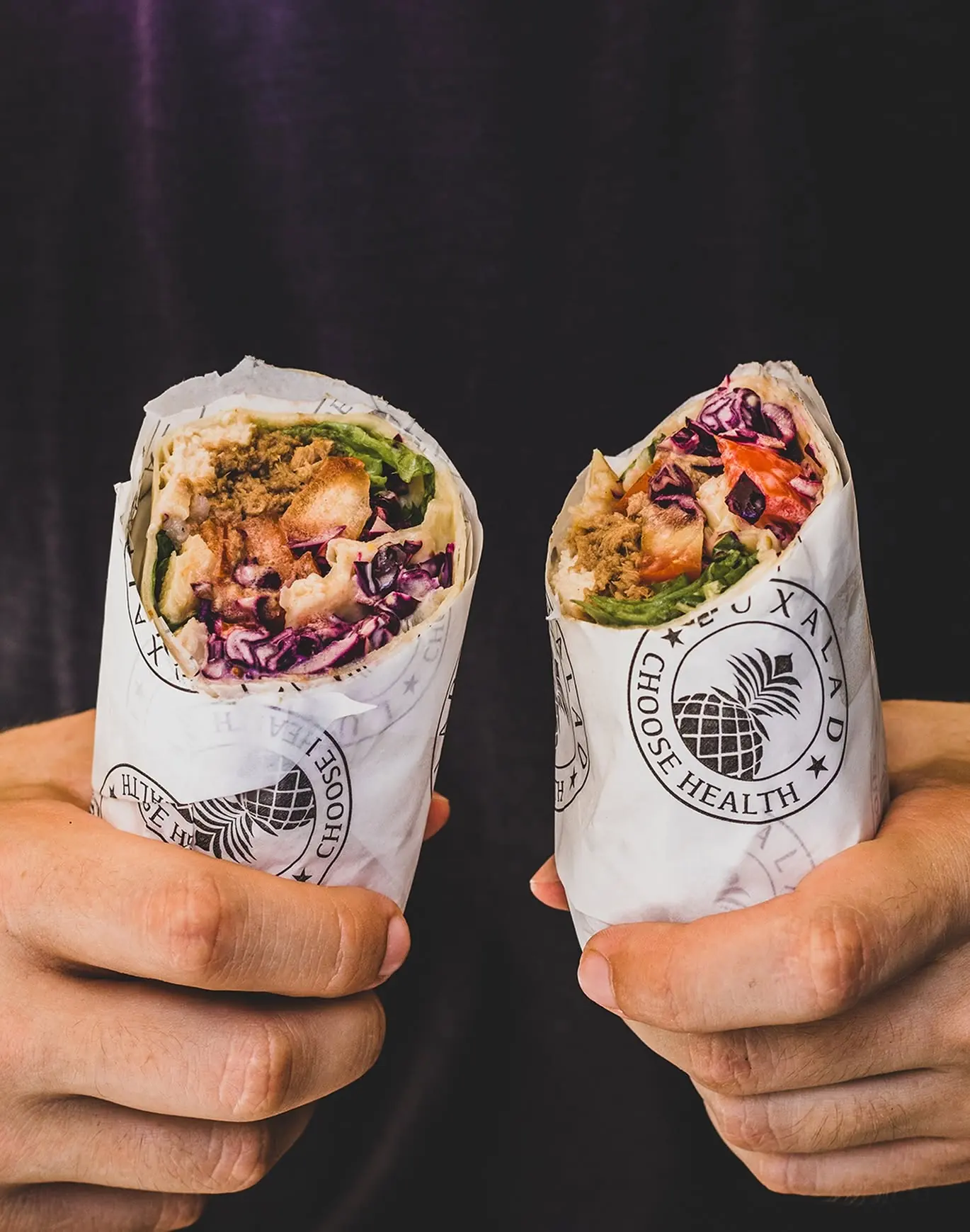 Two Luxalad wraps held in their branded paper