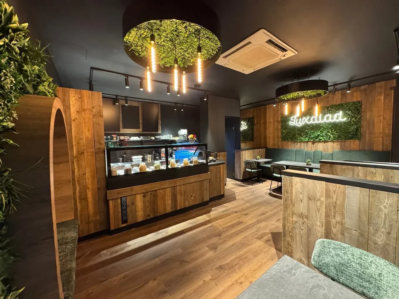 Inside Luxalad Gent, with its green living wall and counter seating