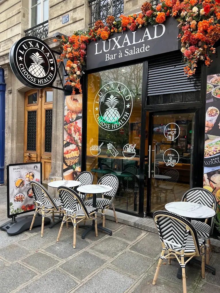 The Paris terrace tables under the Luxalad sign