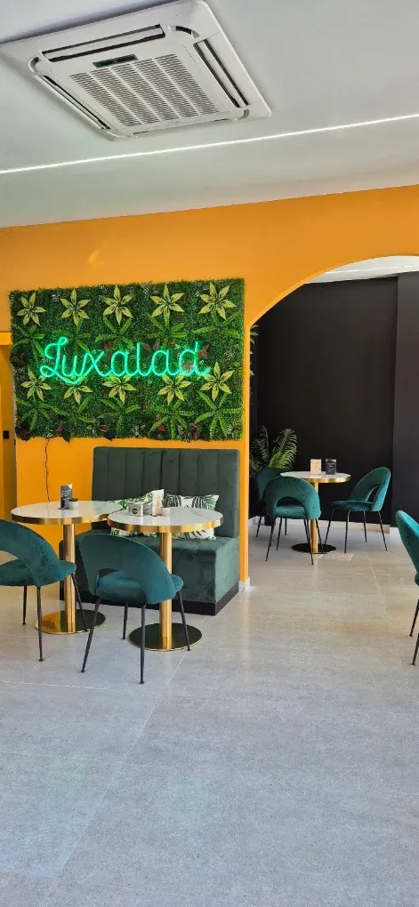 The green neon Luxalad sign and seating inside the Torrevieja salad bar